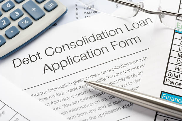 Debt consolidation loan application form with pen, calculator
