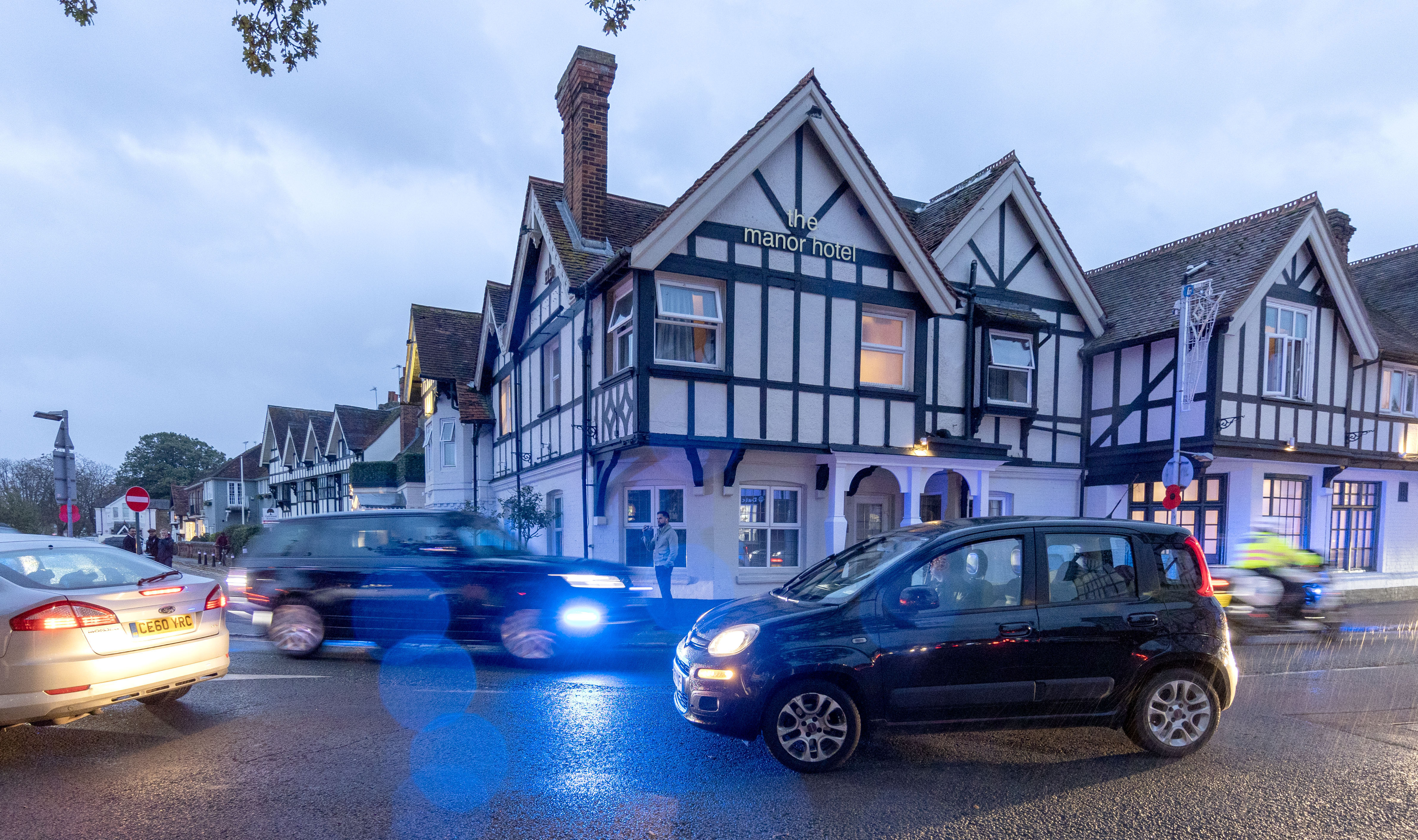 Prince William in his Range Rover with police motorcyclists and emergency protection officers driving past the Manor Hotel